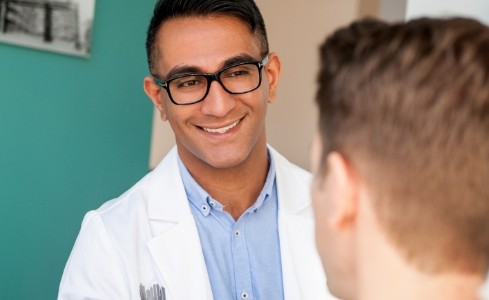 Doctor Saran smiling at dental patient