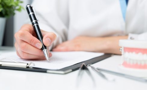 Dental patient reviewing the cost of tooth replacement with dental implants