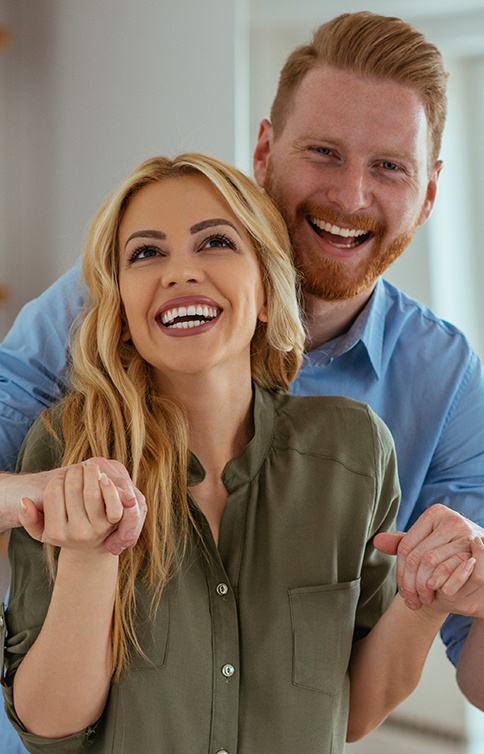 Couple smiling after receiving dental services