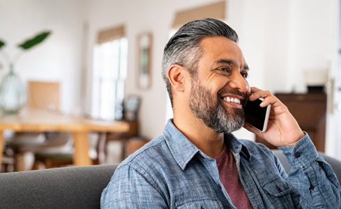 Man smiling while talking on phone