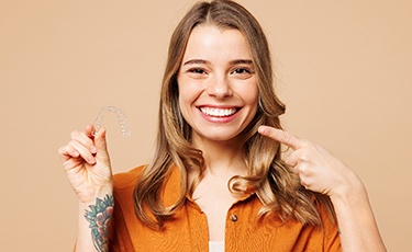 Young woman holding Invisalign tray