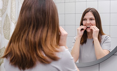 Woman taking off Invisalign tray to brush teeth 
