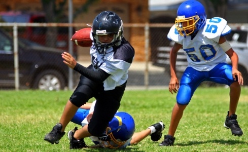 Children playing football using athletic mouthguards