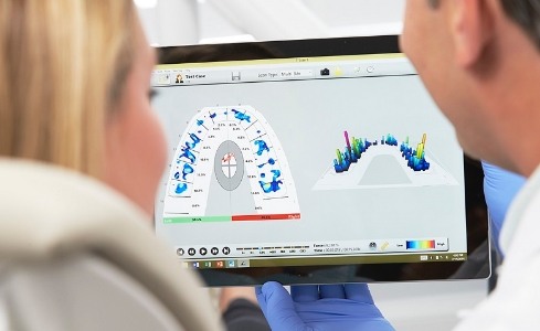 Dentist and dental patient looking at cavity detection system results