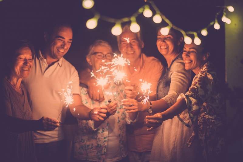 smiling family holding sparklers