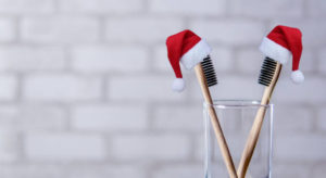 Toothbrushes in a cup with Santa hats on top