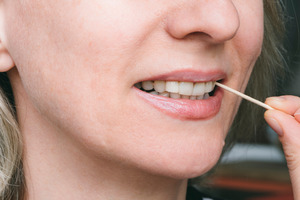 Close-up of woman using toothpick on teeth